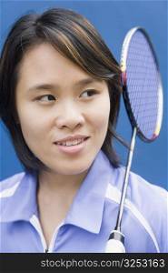 Close-up of a young woman with a badminton racket and smiling