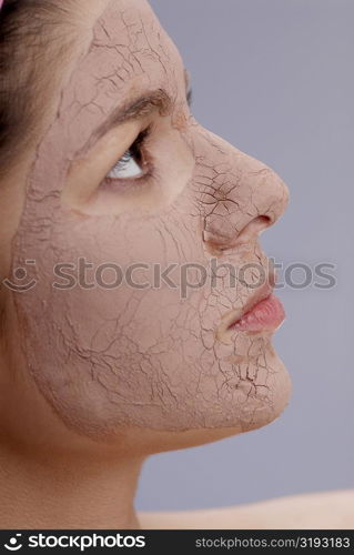 Close-up of a young woman with a facial mask