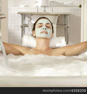 Close-up of a young woman with a facial mask relaxing in a bathtub