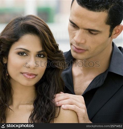 Close-up of a young woman with a mid adult man behind her