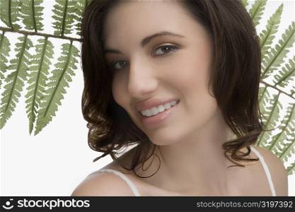 Close-up of a young woman with fern