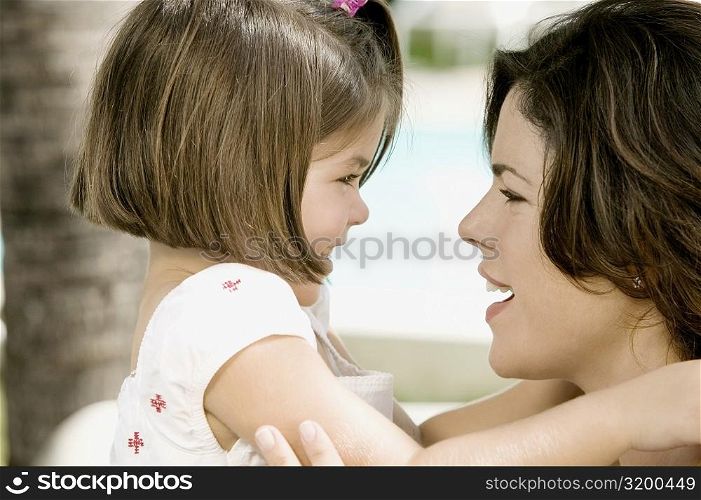 Close-up of a young woman with her daughter smiling