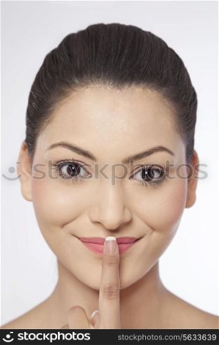 Close-up of a young woman with her finger on lips
