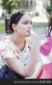 Close-up of a young woman with her hands on her chin