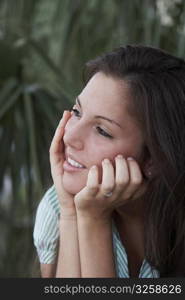 Close-up of a young woman with her hands on her chin