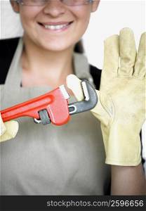 Close-up of a young woman with her thumb in an adjustable wrench