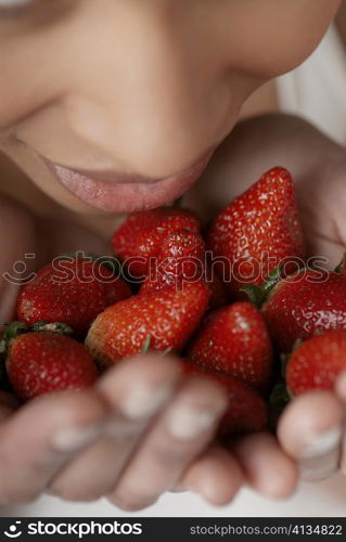 Close-up of a young woman with strawberries in her hands