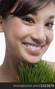 Close-up of a young woman with wheatgrass