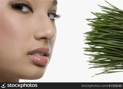 Close-up of a young woman with wheatgrass