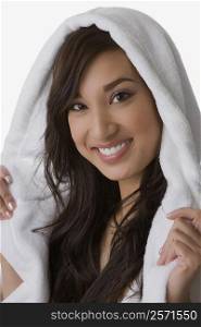 Close-up of a young woman wrapped in a towel and smiling