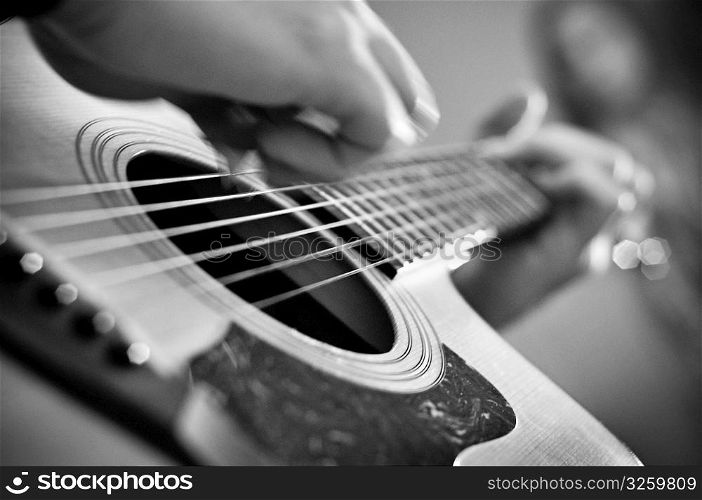 Close-up of acoustic guitar playing.