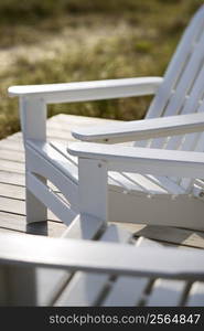 Close-up of Adirondack chairs on deck.