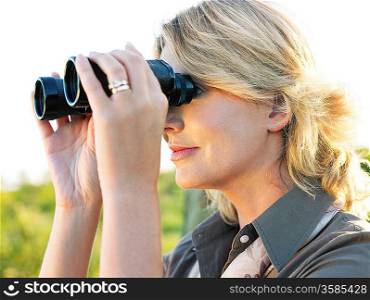 Close-up of adult woman looking through binoculars