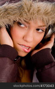 close up of adult woman with woolen coat listening music on an isolated white background