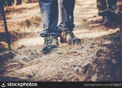 Close up of adventure man feet walk on a mountain path.