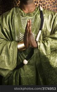 Close-up of African-American mid-adult man wearing traditional African clothing in prayer.