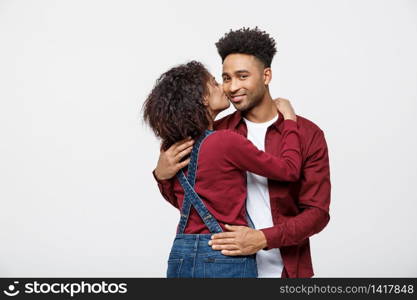Close-up of African American young couple kissing over white background studio.. Close-up of African American young couple kissing over white background studio