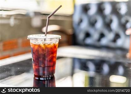 Close-up of Americano ice coffee or black coffee in cup mug on glass wood desk office desk in coffee shop at the cafe,during business work concept