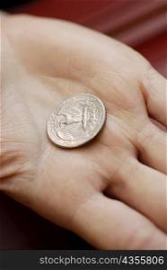 Close-up of an American dollar coin on a person&acute;s hand
