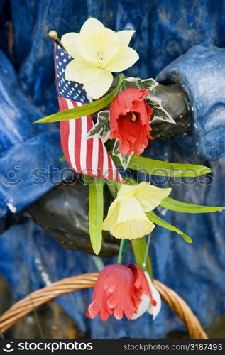 Close-up of an American flag and flowers in a statue&acute;s hand, USA