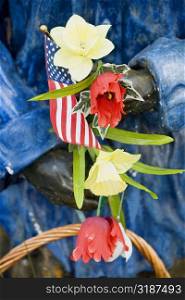 Close-up of an American flag and flowers in a statue&acute;s hand, USA