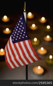 Close-up of an American flag with oil lamps burning in the background