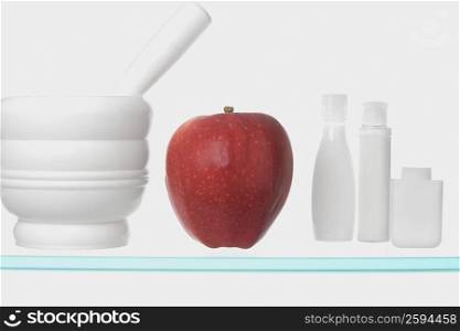 Close-up of an apple with mortar and pestle on glass