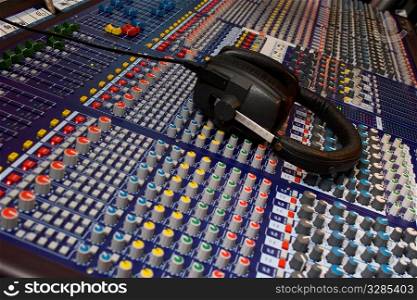 Close up of an audio visual mixing desk complete with headphones