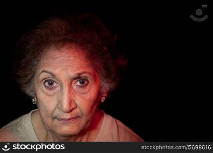 Close-up of an elderly senior woman over black background