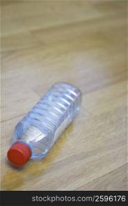 Close-up of an empty water bottle on a hardwood floor