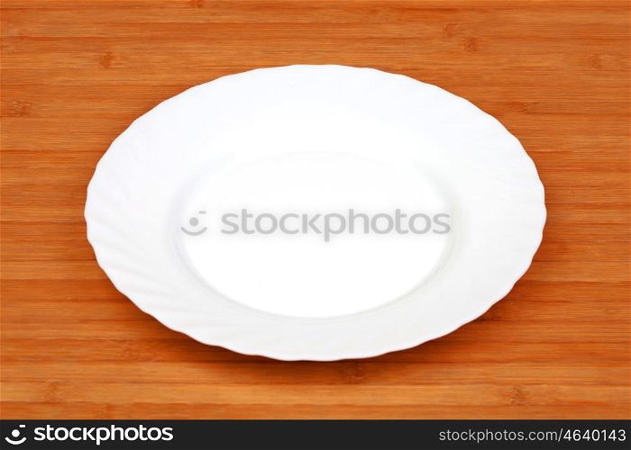 Close-up of an empty white plate on wooden background