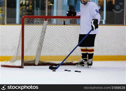 Close-up of an ice hockey player standing in front of a goal post