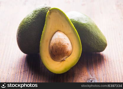 Close-up of an juicy organic avocado on wooden table. Healthy food concept