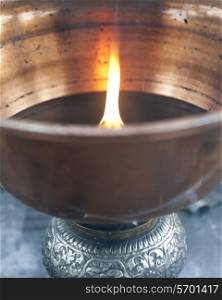 Close-up of an oil lamp burning at Taktsang Monastery, Paro Valley, Paro District, Bhutan