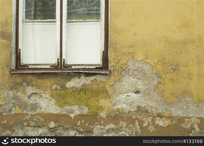 Close-up of an old window on a weathered wall