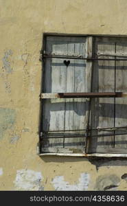 Close-up of an old window on a weathered wall