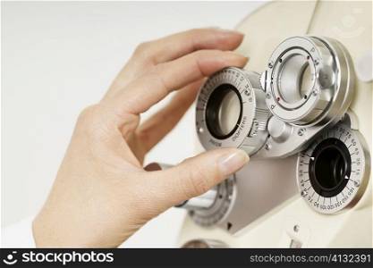 Close-up of an optometrist&acute;s hand adjusting a phoropter
