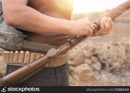Close up of an unrecognizable hunter, loading shotgun, holds a shotgun and ammunition in his hand. High quality photo. Close up of an unrecognizable hunter, loading shotgun, holds a shotgun and ammunition in his hand.