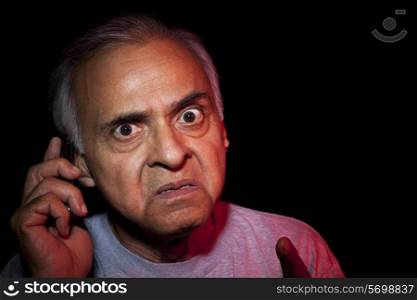 Close-up of and angry old man talking on mobile phone