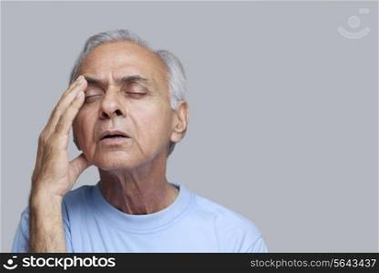 Close-up of and elderly man suffering from headache with eyes closed