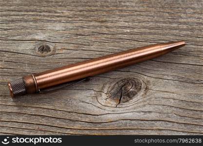 Close up of antique metal pen on weathered wood.