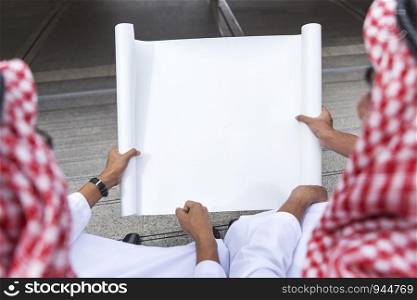 Close up of Arab business mans hand holding empty white paper board with free copy space. Picture for add text message. Backdrop for design art work.