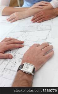 Close-up of architects examining floor-plans