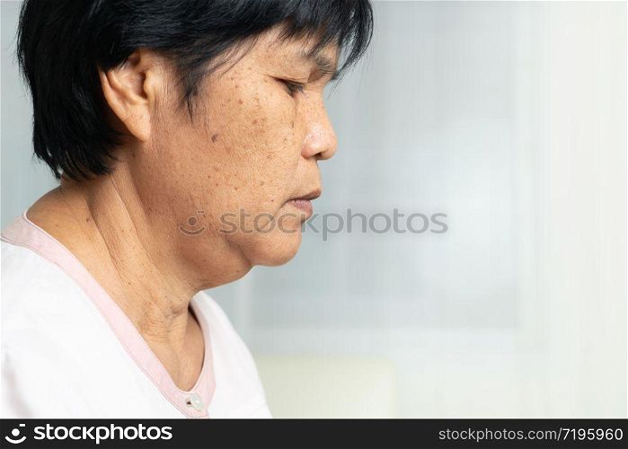 Close-up of Asian elder woman face with wrinkled skin condition. side view