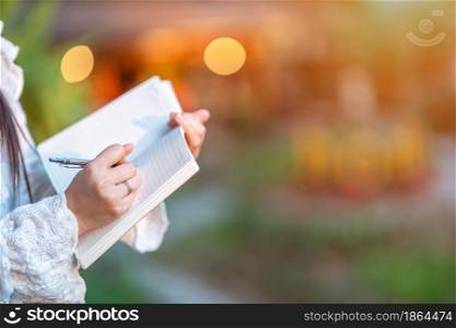 Close-up of asian freelance people Businesswoman stand Taking written Notes to on notebook at the cafe,Business Lifestyle