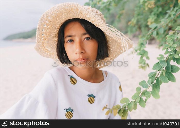 Close-up of Asian little girl posing on the beach in the morning. Summer concept thailand