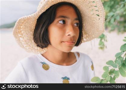 Close-up of Asian little girl posing on the beach in the morning. Summer concept thailand