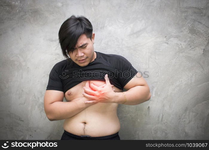 close up of asian man suffering from heart ache over grey concrete background, healthcare and problem concept