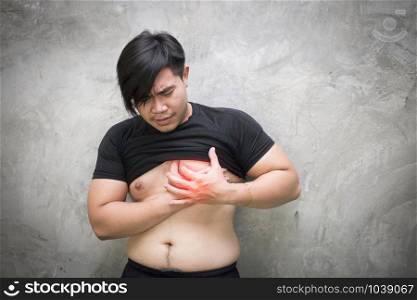 close up of asian man suffering from heart ache over grey concrete background, healthcare and problem concept