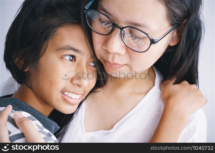 Close-up of Asian mother and daughter hugging each other with love in the room at her home